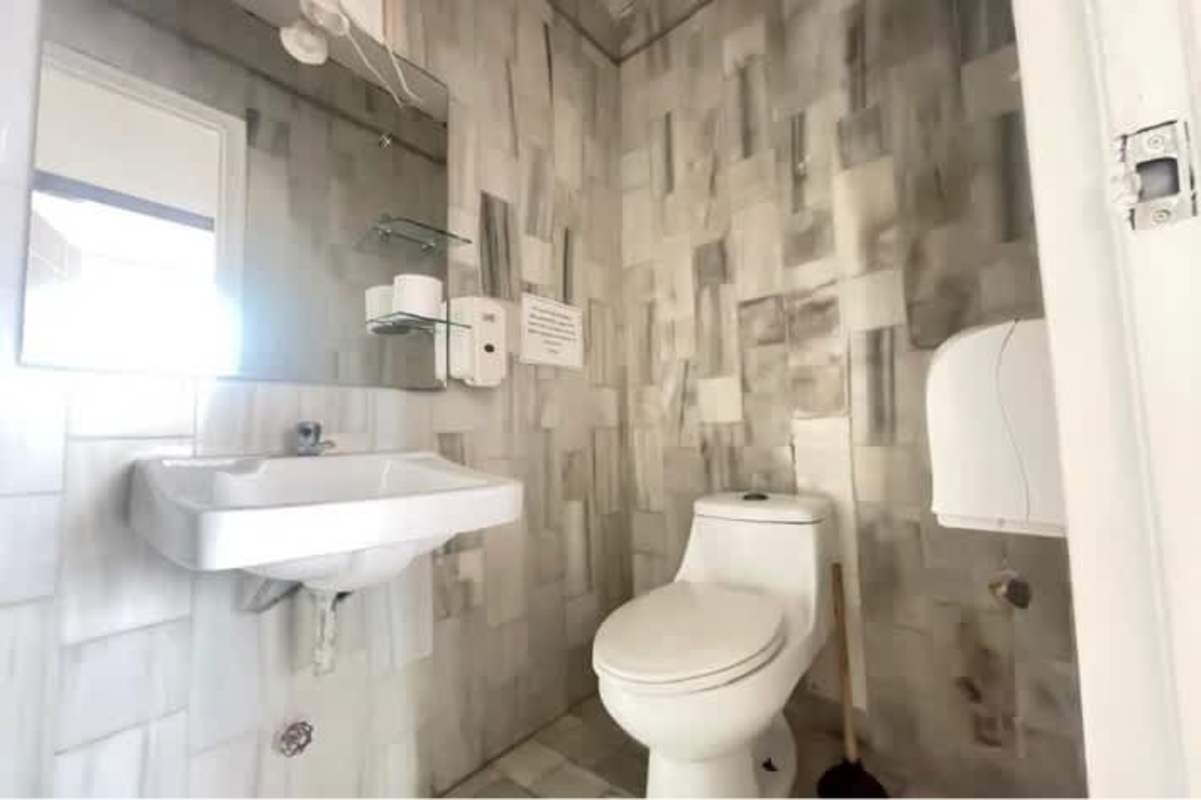 Minimalist bathrooms with tile and mirrors in PH BICSA Panama office rental