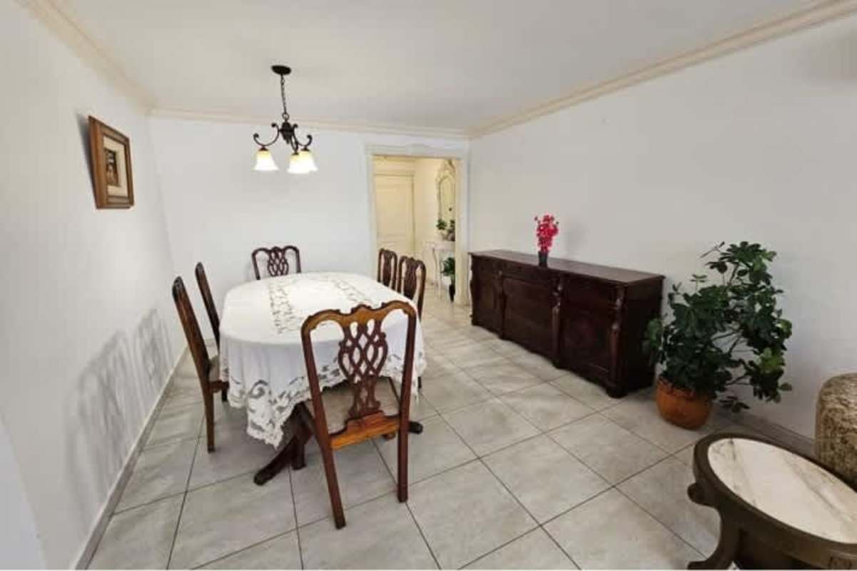 Dining room with wooden furniture, chandelier lighting, large windows in PH Mar Plaza apartment Panama City