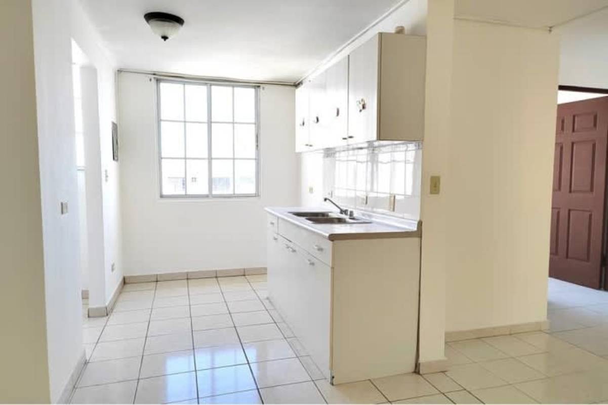 Minimalist kitchen with white cabinets bright window PH Mystic Hills affordable apartment Panama