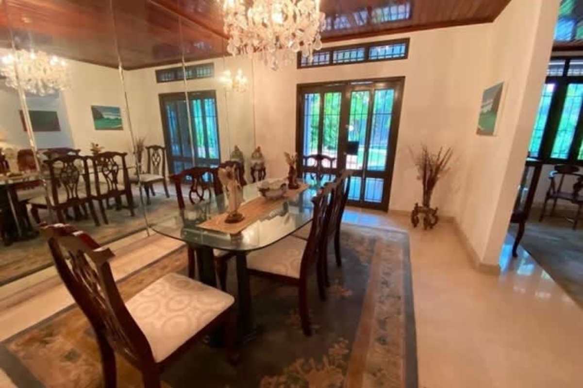 Dining room with glass table, chandelier, wood ceiling, wall mirrors in Altos del Golf Panama
