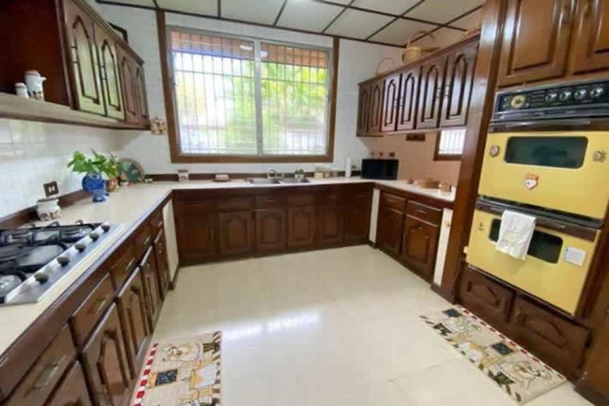Traditional kitchen with wood cabinets, double oven, and corner sink in Panama City