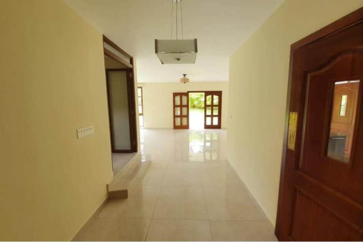 Open hallway with large windows and tiled floors in Senderos de Clayton Panama luxury house