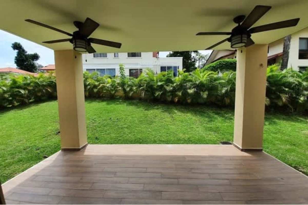 Spacious covered terrace with fans overlooking green backyard Senderos de Clayton Panama luxury house