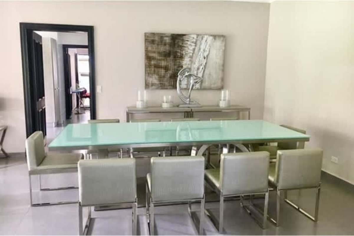 Modern dining room with glass top table metal chairs minimalist decor Costa del Este Panama