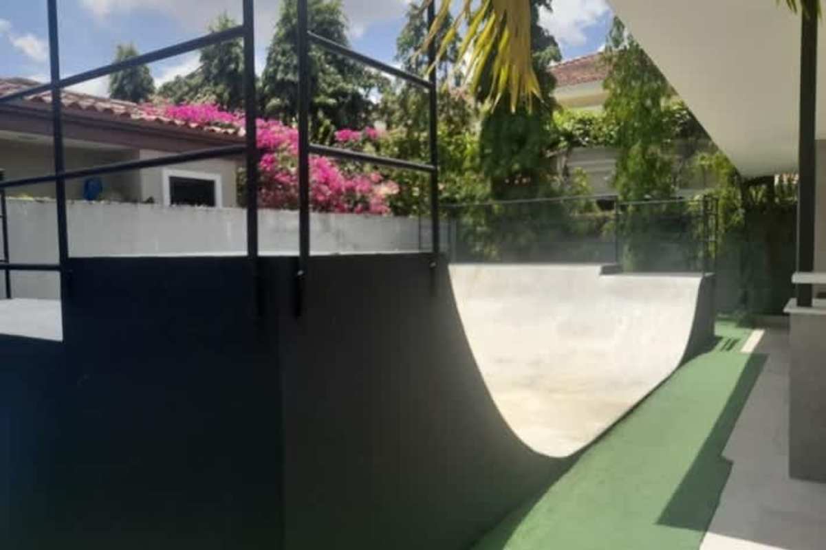 Modern living room with sliding glass doors opening to patio and lush garden Costa del Este Panama