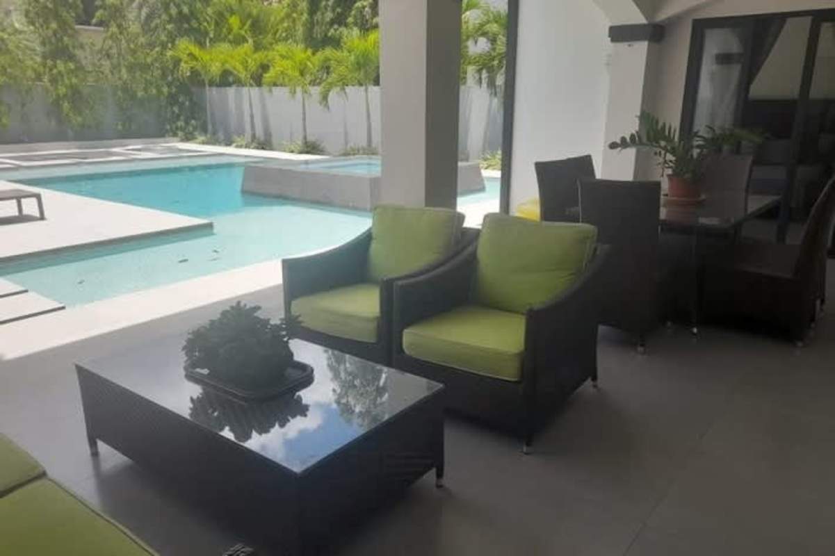 Contemporary pool with built-in jacuzzi area in backyard with two-story luxury house Costa del Este Panama