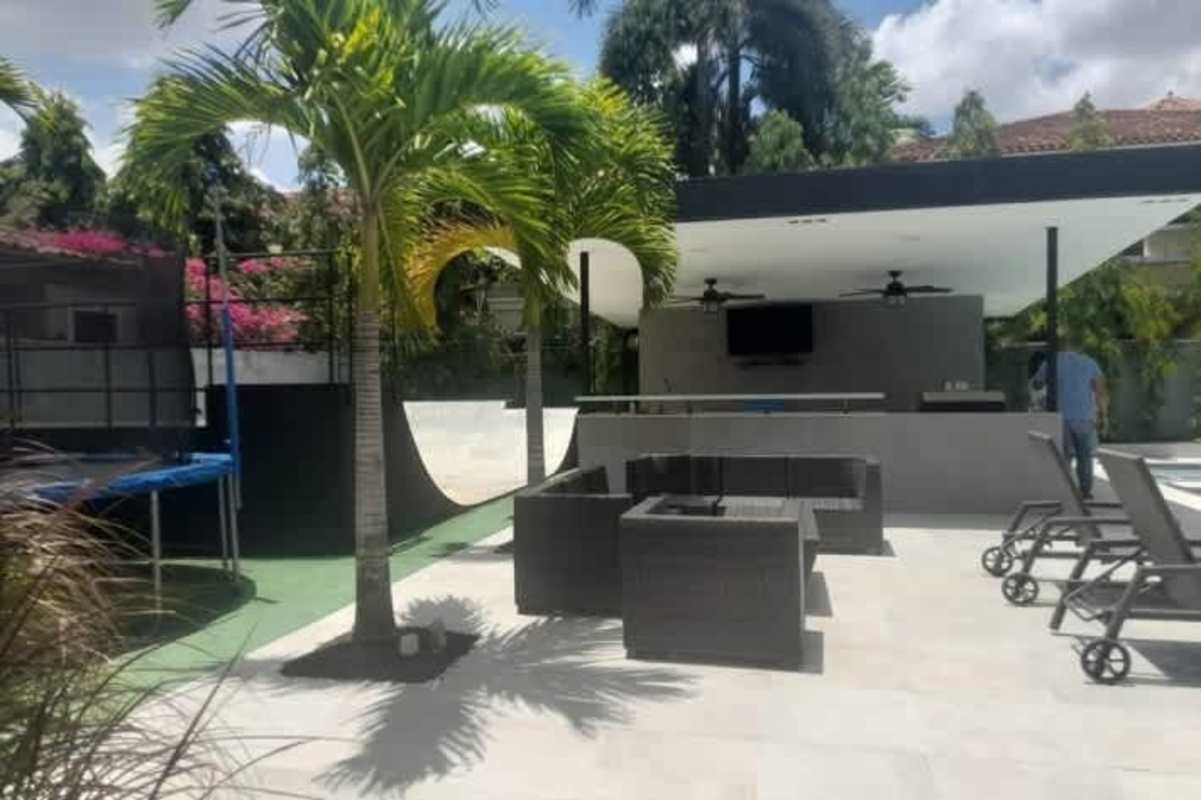 Modern backyard with skate ramp lounge trampoline sun loungers and palm trees Costa del Este Panama