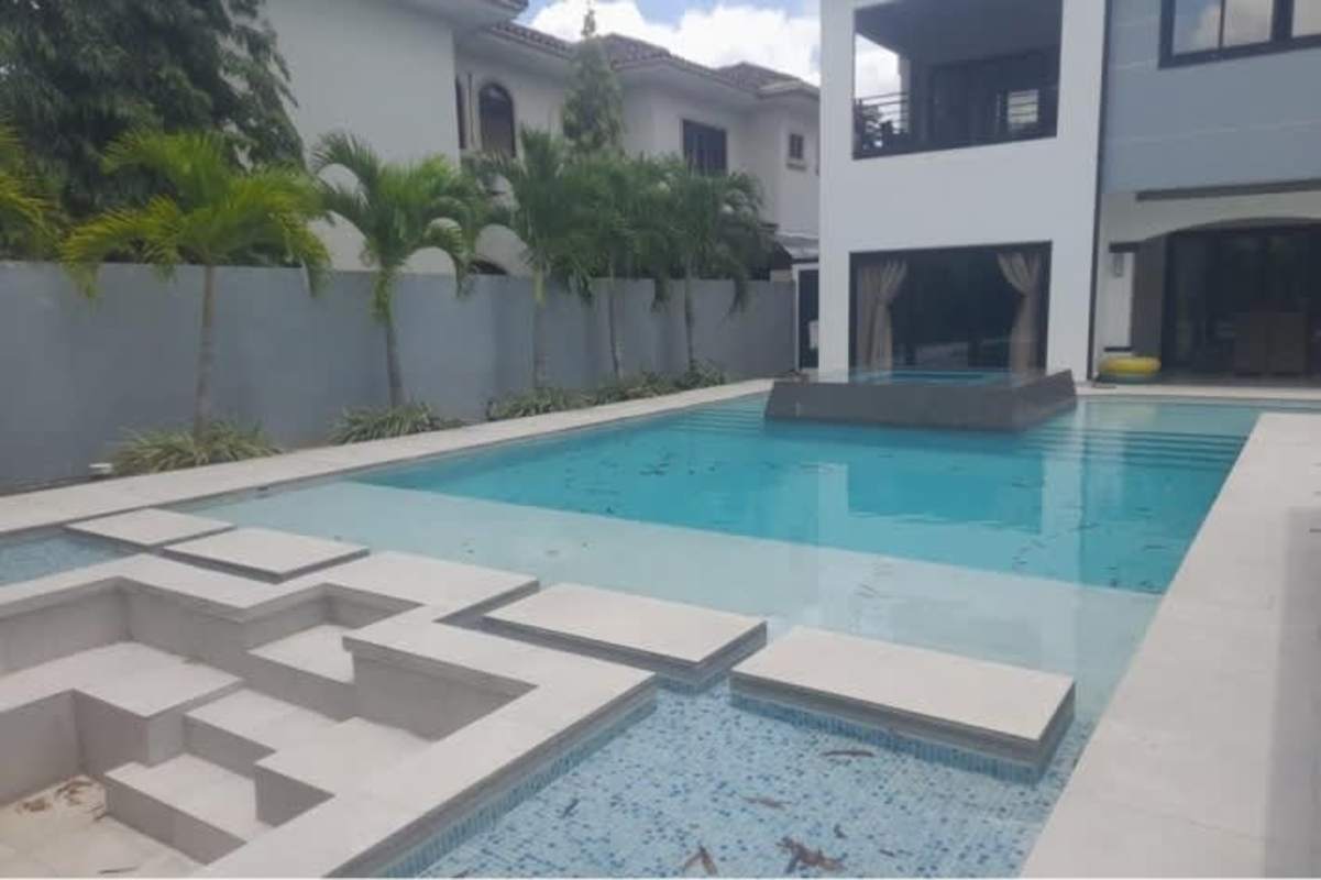 Luxury backyard with entertainment bar, lounge area, trampoline and lush plants in Costa del Este Panama