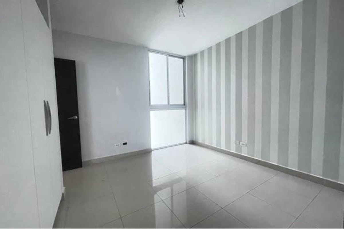 Empty bedroom with tile floor, neutral walls, built-in closet PH San Francisco Bay Panama