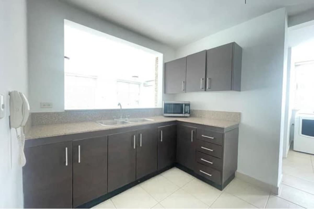 Spacious living room with large windows and balcony access in Embassy Club Clayton Panama