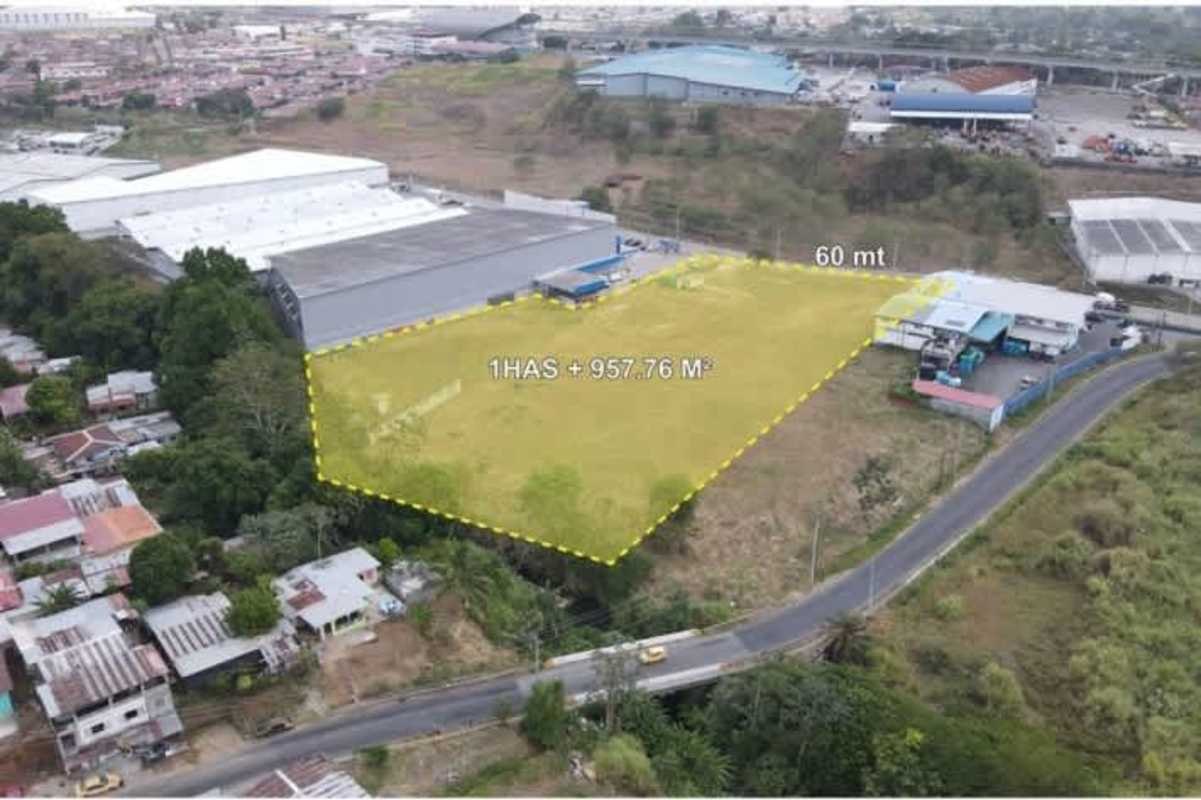 Aerial view of industrial warehouses and commercial buildings adjacent to vacant land for sale in Mañanitas Tocumen Panama
