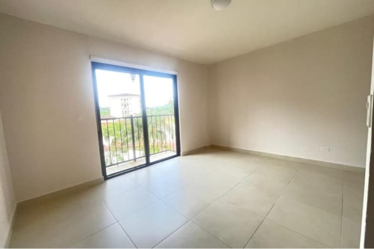 Bedroom with large windows and balcony overlooking greenery at PH Clayton Residence Panama City