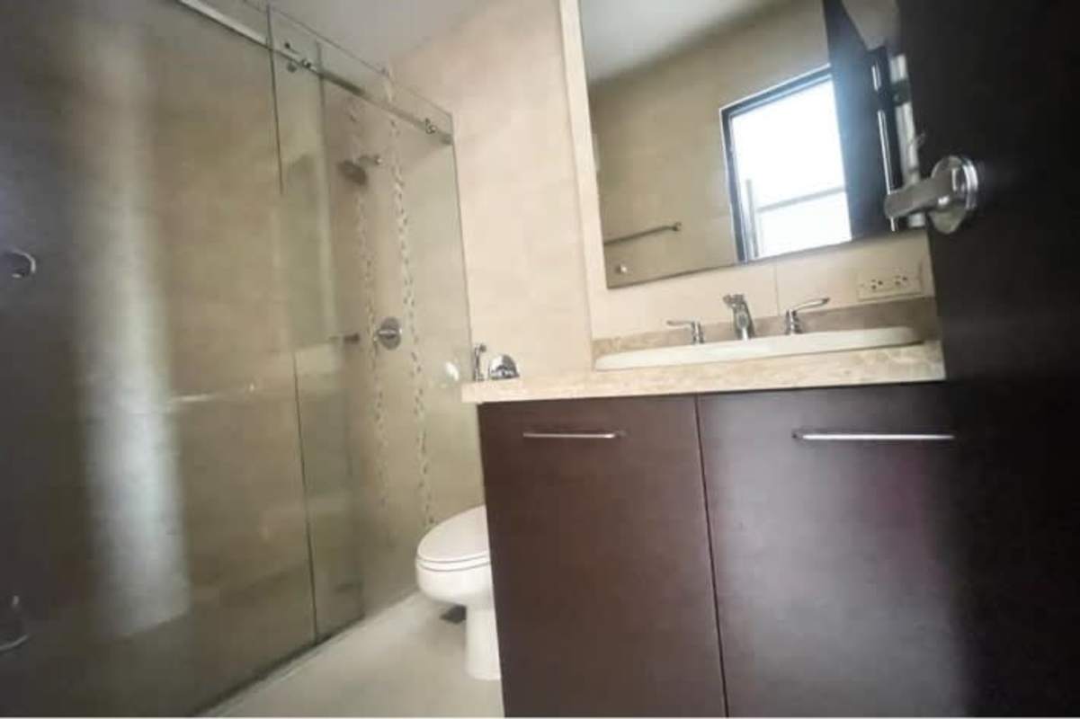 Modern bathroom with glass-enclosed shower and marble vanity in PH Clayton Residence Clayton Panama City