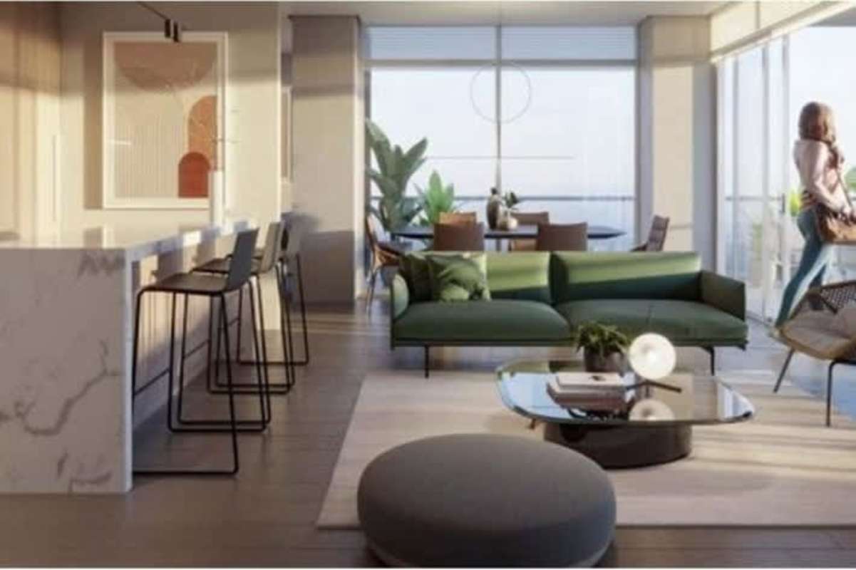 Open-plan living room with green sofa, large windows, modern kitchen at PH Nogal Costa del Este