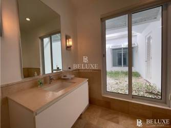 Elegant bedroom with en-suite bathroom, large windows overlooking lake at OceanLake Buenaventura Panama