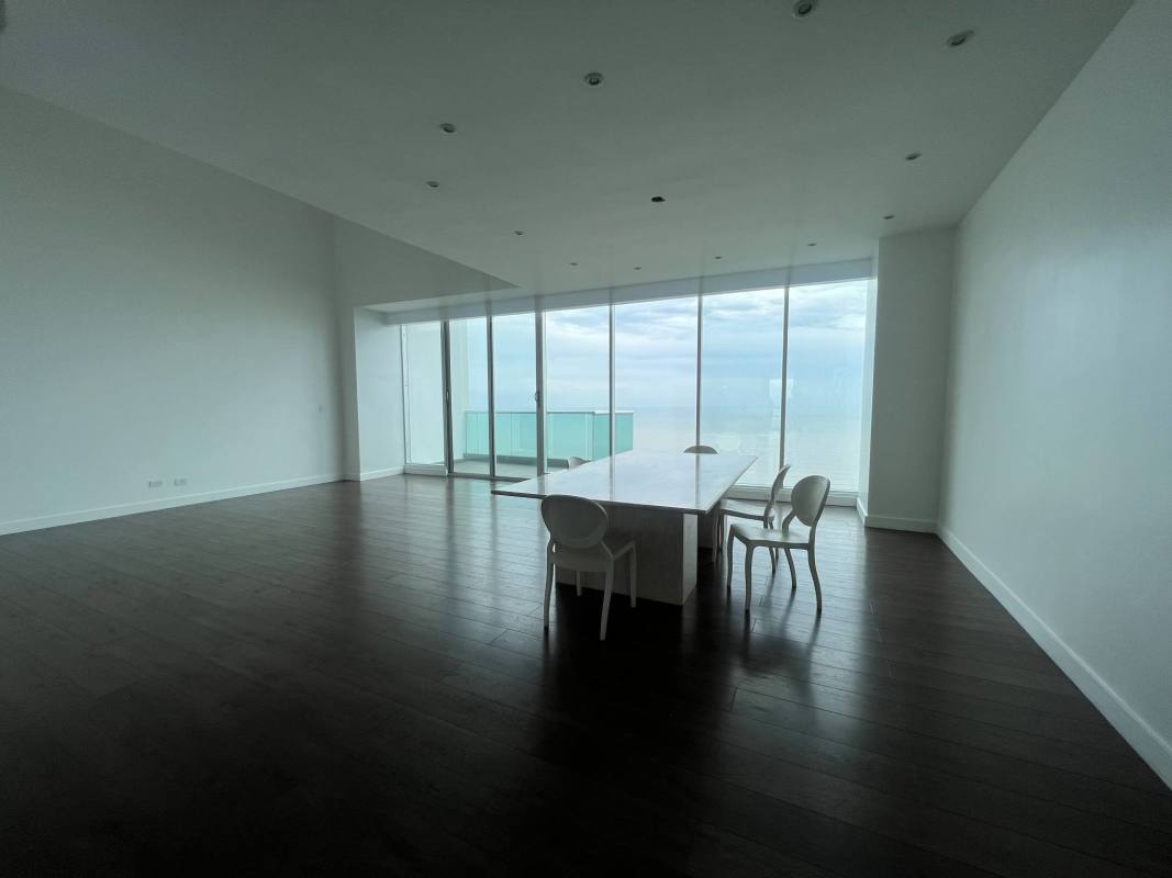Modern minimalist dining space with marble floor, ocean view windows in luxury penthouse Panama City