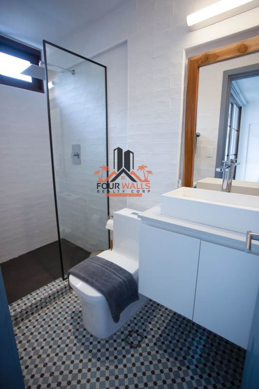 Minimalist bathroom with glass shower, white tiles, and pattern flooring PH Plaza Santa Ana Casco Viejo