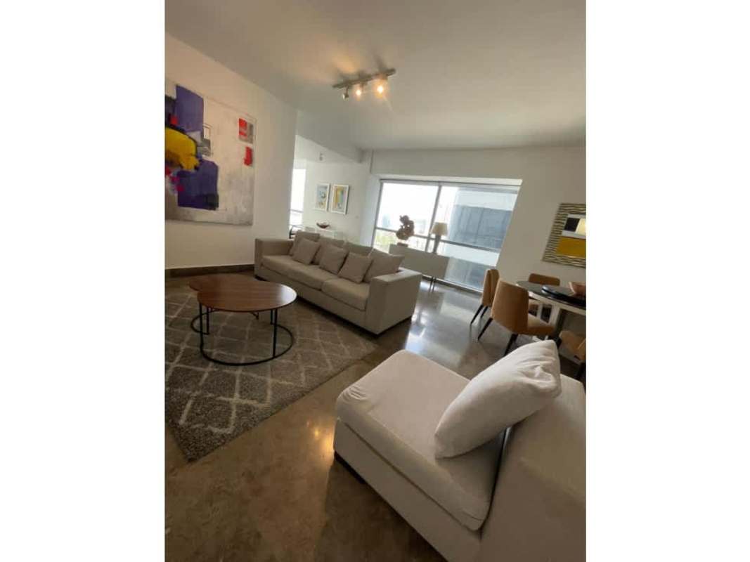 Spacious furnished living room with beige sectional and abstract art at Yoo Panama