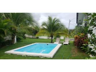 Living room with black sofa, egg chair, tiled floors, modern rustic style at PH Piedras Gordas Villages