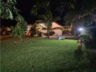 Bedroom with queen bed, chandelier, tiled floors and garden view at PH Piedras Gordas Villages Panama