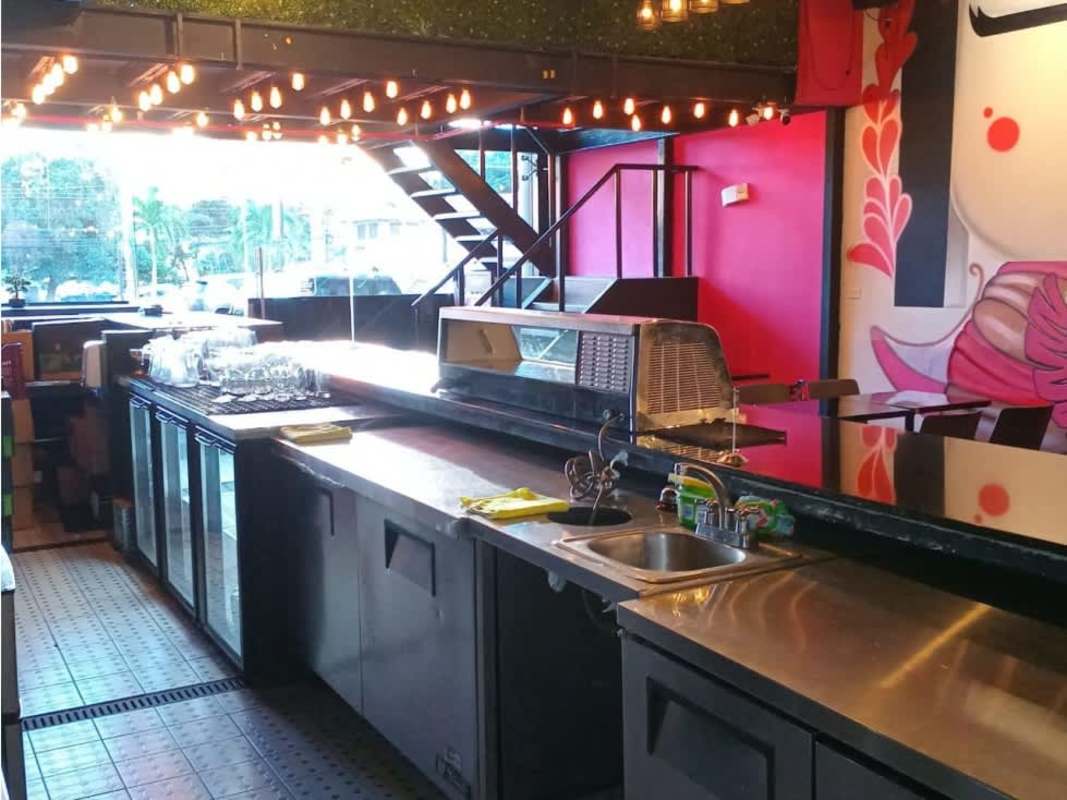 Restaurant bar counter with bottle display, stools, interior decor in Panama City