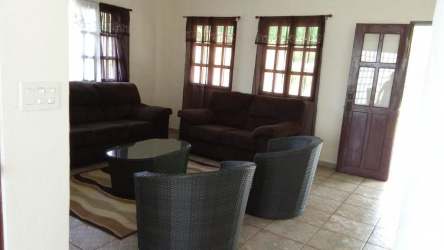 Spacious living area with sofa set, tiled floors, and windows at Coronado beach house Panama