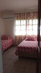 Bedroom with two beds, AC, pink accents in Coronado vacation house Panama