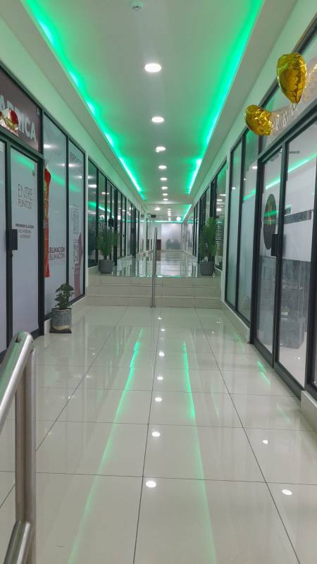 Wide commercial retail passageway corridor with glass-fronted stores and LED lighting in Panama City Tech Market