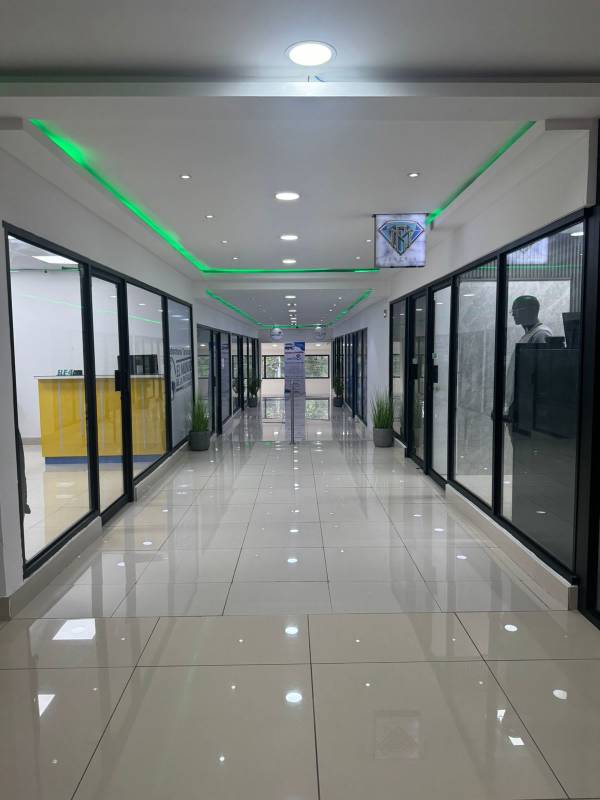 Empty showroom commercial space interior with glass dividers and tiled floor in Tech Market Los Pueblos
