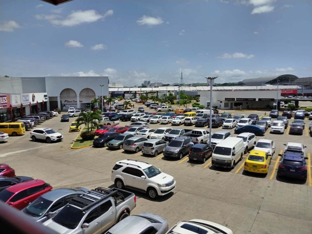 View of the busy shopping center parking lot at Tech Market Los Pueblos Panama