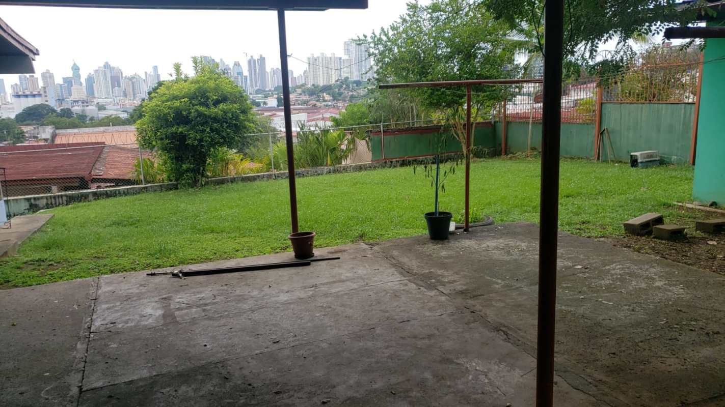 Bright living room with tile floor and large windows opening to backyard garden in Villa de las Fuentes