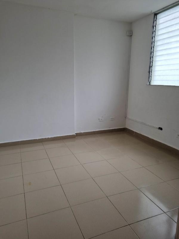 Empty bedroom or living space with neutral tiles and window in Río Abajo apartment Panama