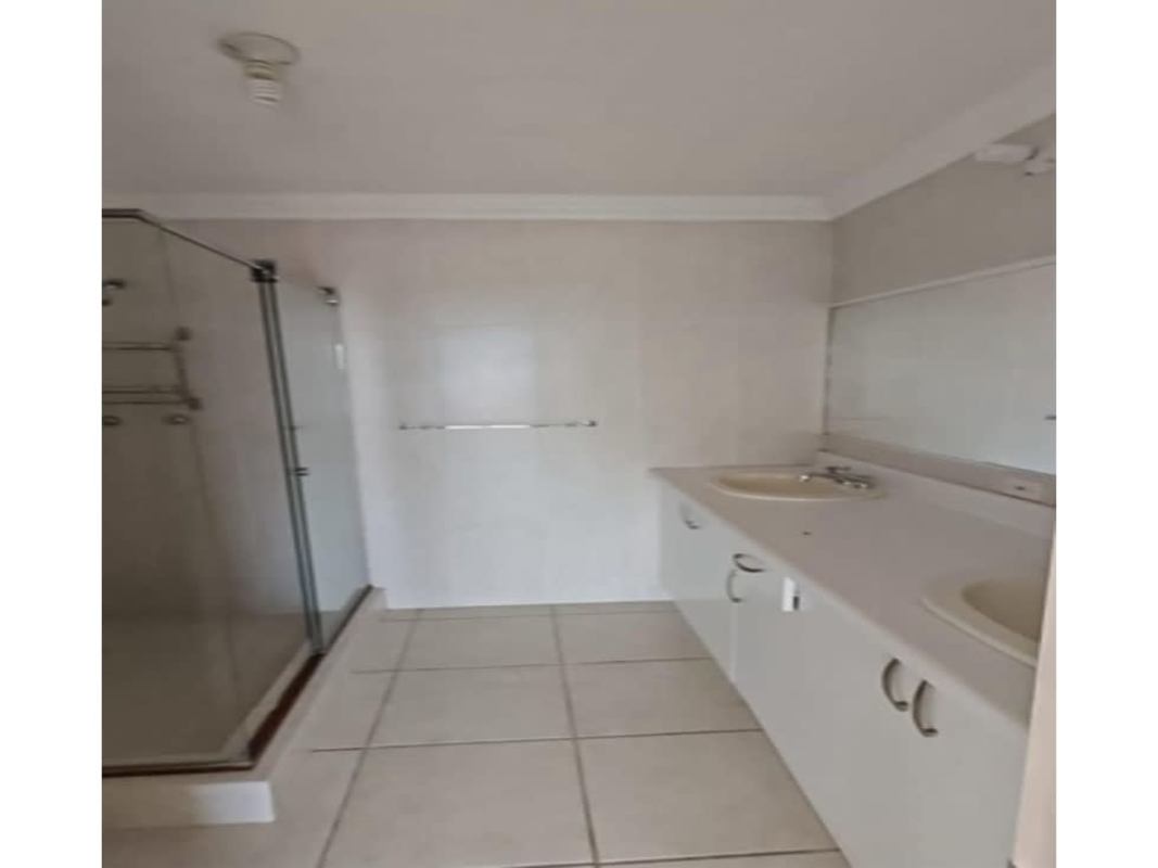 Modern bathroom with double sink vanity and glass shower in house Brisas del Golf Panama