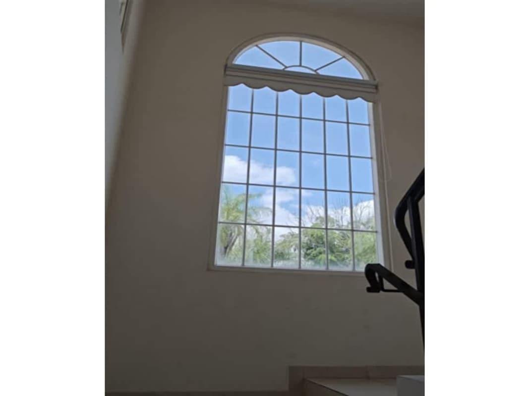 Bright stair landing with arched window allowing natural light in house Brisas del Golf Panama