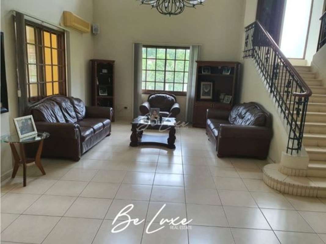 Living room with double height ceiling, leather sofas, natural light in luxury villa Clayton Panama
