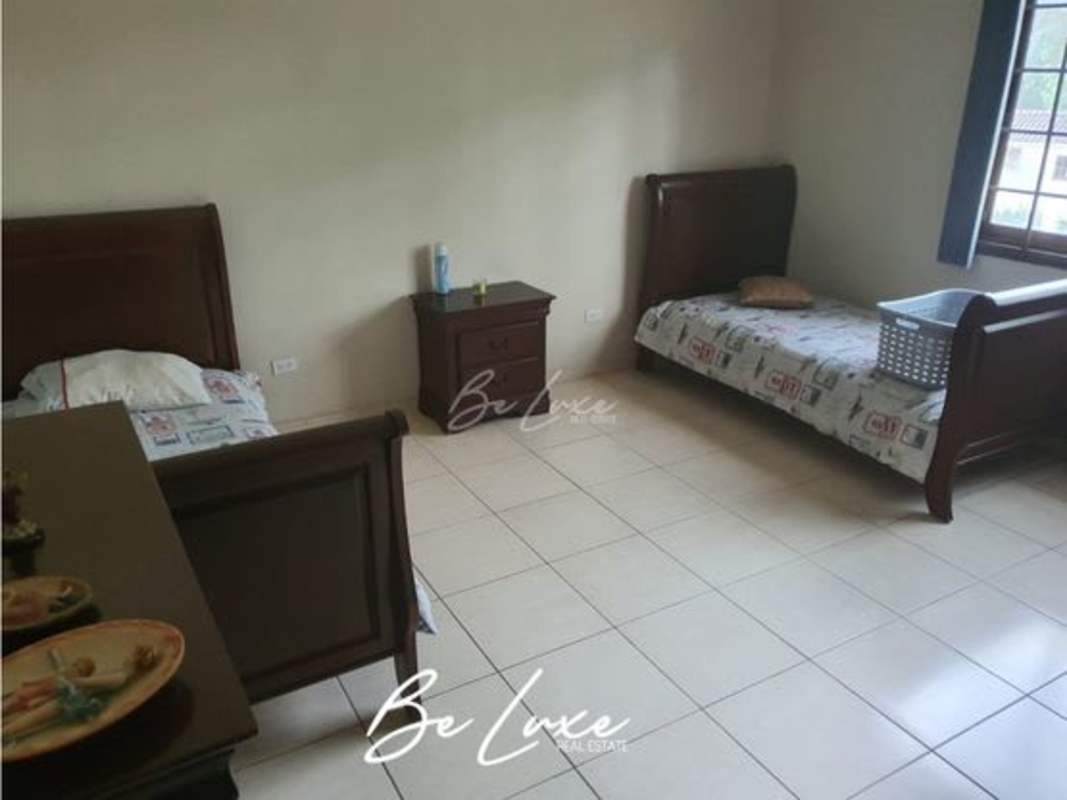 Bedroom with twin beds, large windows and tile floor overlooking gardens Clayton Panama