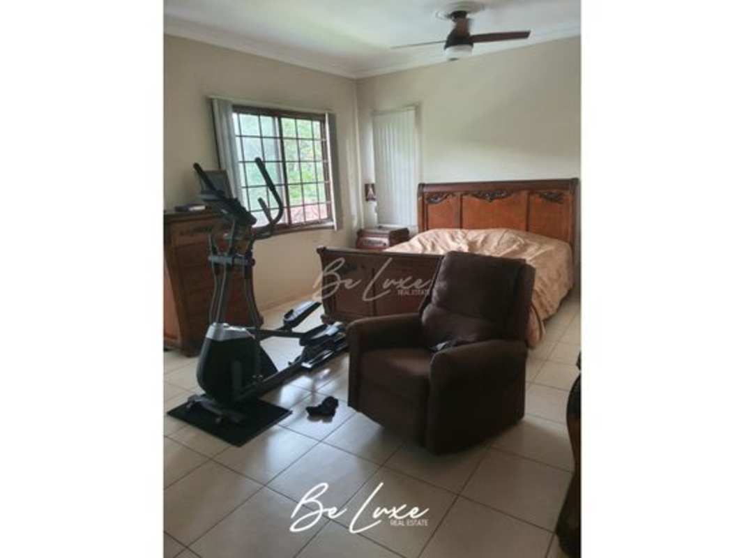 Bedroom with twin beds, built-in furniture, window Clayton luxury home Panama