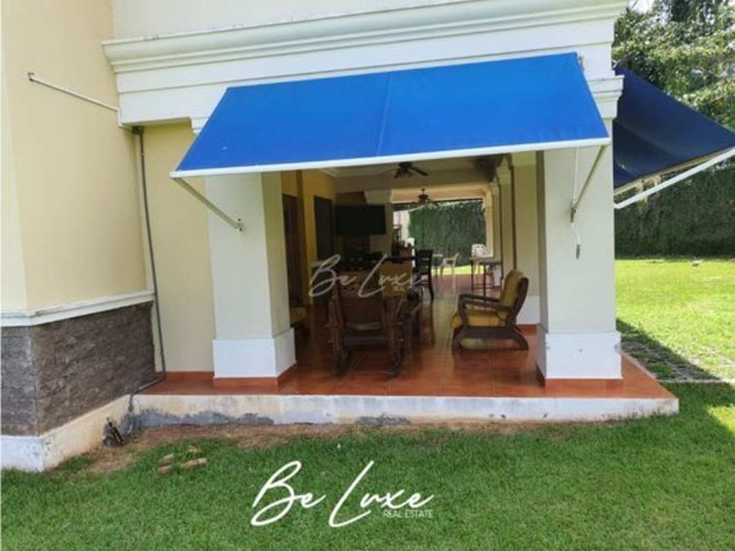 Covered patio space with blue canopy next to backyard at luxury villa in Clayton Panama