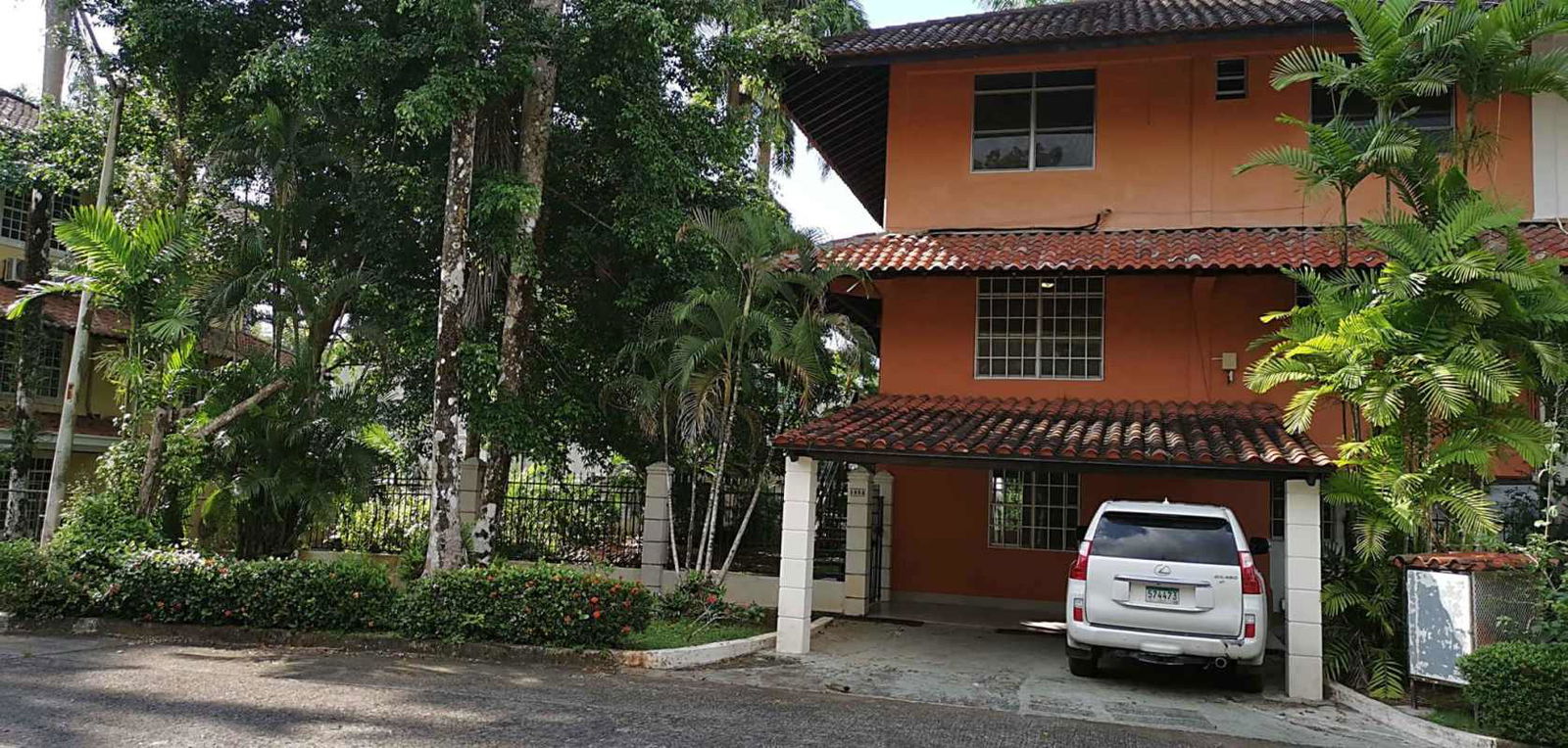 Private gated entrance driveway with tropical trees of Clayton home Panama City