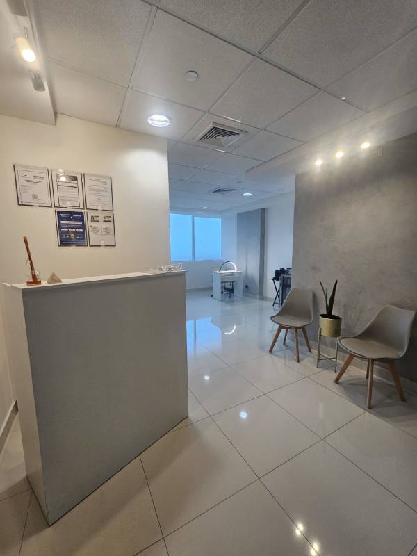 Modern minimalist medical reception with chairs and potted plants in Punta Pacífica