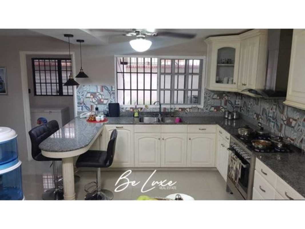 Living room with sofas, large TV, ceiling fans and sliding doors opening to the terrace in Bethania residence