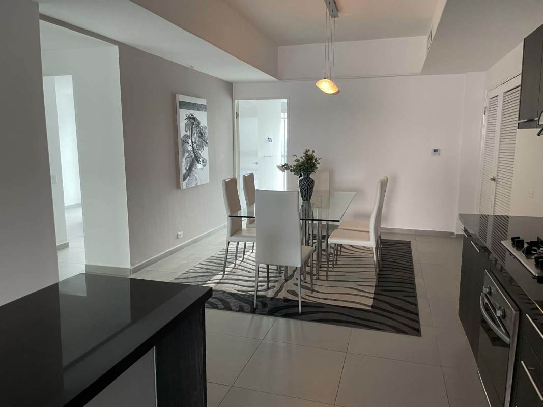 Dining room with glass table white chairs minimalist open layout Yacht Club Tower Panama
