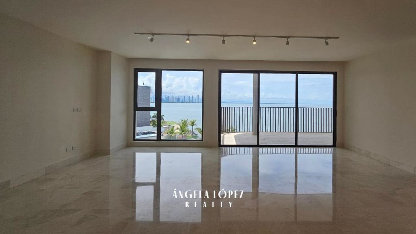 Large unfurnished open living dining space with marble floors and floor-to-ceiling ocean view windows in Seascape Ocean Reef