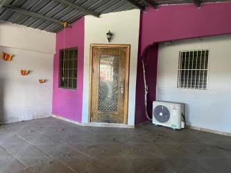 Covered exterior porch with purple and white walls barred windows and split AC unit in Vacamonte Panama