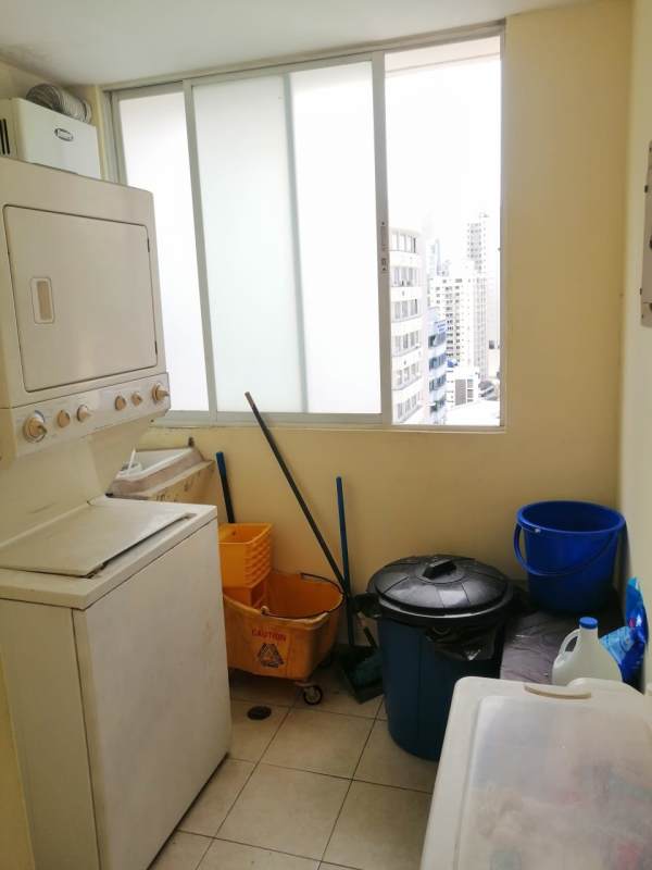 Laundry room with stacked washer dryer, window city view at PH Marquez San Miguelito