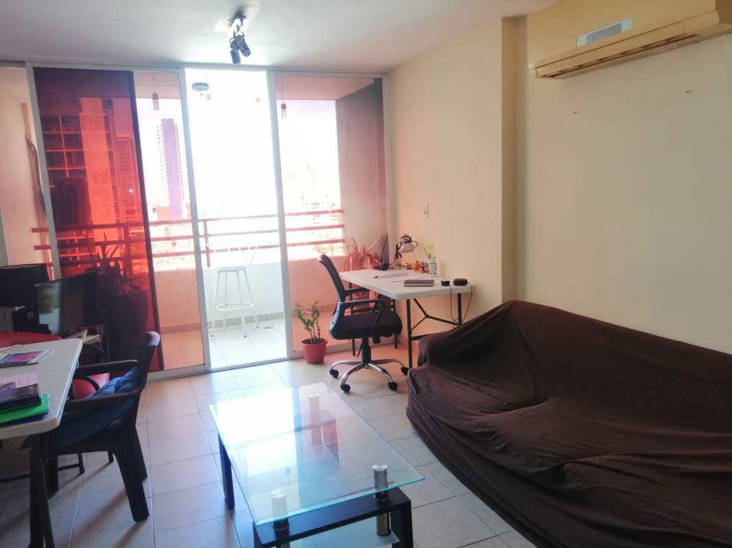 Living room with workspace area, balcony access, sliding doors and AC unit at PH Marquez Panama City