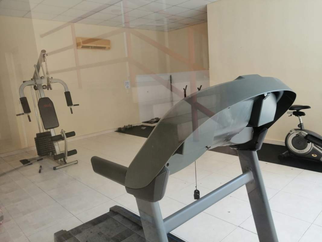 Modern apartment gym with treadmill, bike, weights in PH Marquez San Miguelito