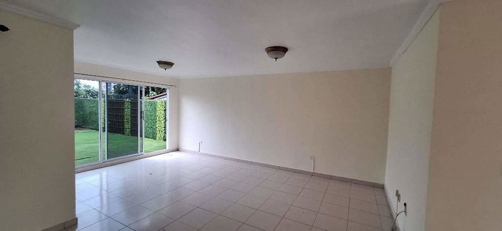 Contemporary kitchen with granite island, wood cabinets and large window in Villa Zaita Panama house