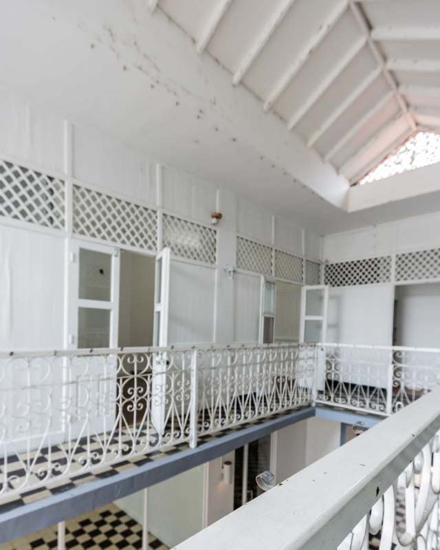 Interior corridor with black and white checkered ceramic flooring and colonial ironwork in Casco Viejo leasing building Panama