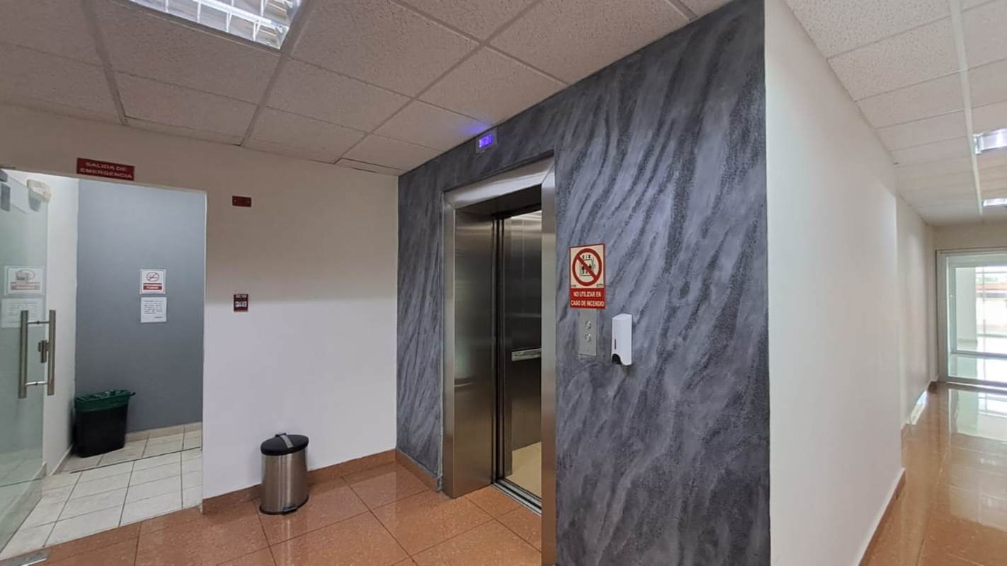 Interior hallway with elevator and polished tile floors in Plaza Korintho commercial center Panama City